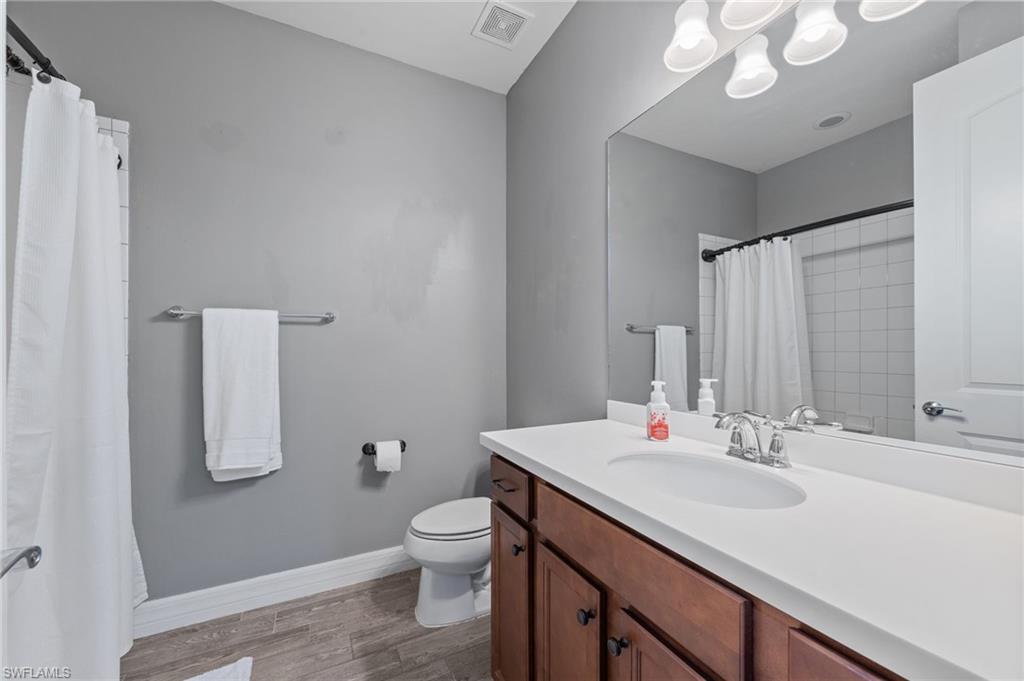 4914 Seton Way Immokalee, FL 34142 - Photo 23 of 46 Bathroom with vanity, dark wood finished floors, and a shower with curtain