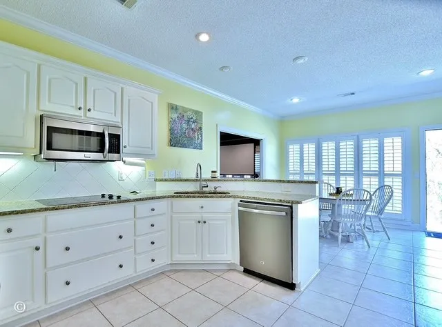 a kitchen with granite countertop white cabinets and white appliances