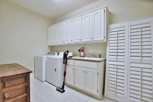 a utility room with cabinets washer and dryer