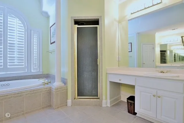 a spacious bathroom with a tub sink and mirror