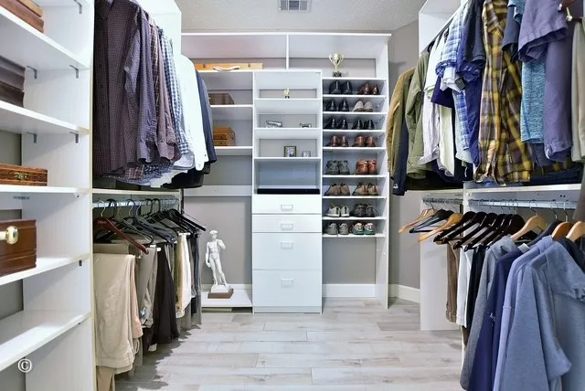 a view of walk in closet with clothes and shoes