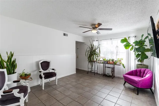 a living room with furniture a window and a potted plant