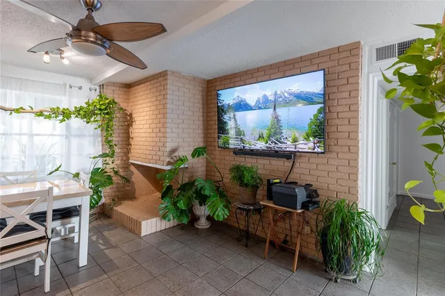 a patio with table and chairs potted plants