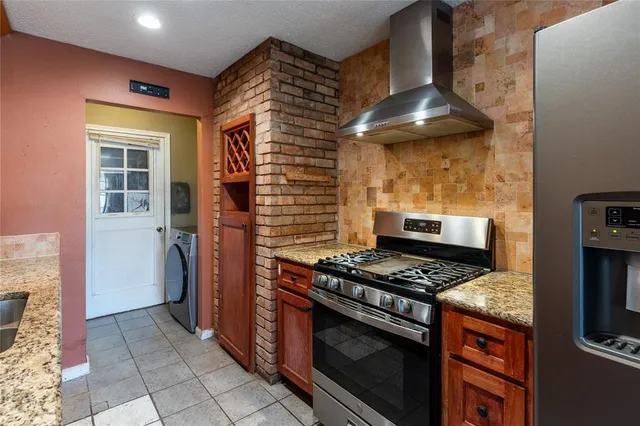 a kitchen with granite countertop a stove and a refrigerator