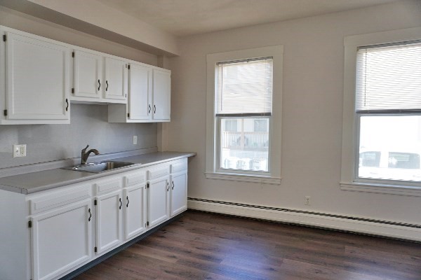 252 Ash Street, Unit 2 Waltham, MA 02453 - Photo 6 of 9 a kitchen with granite countertop white cabinets white stainless steel appliances and window