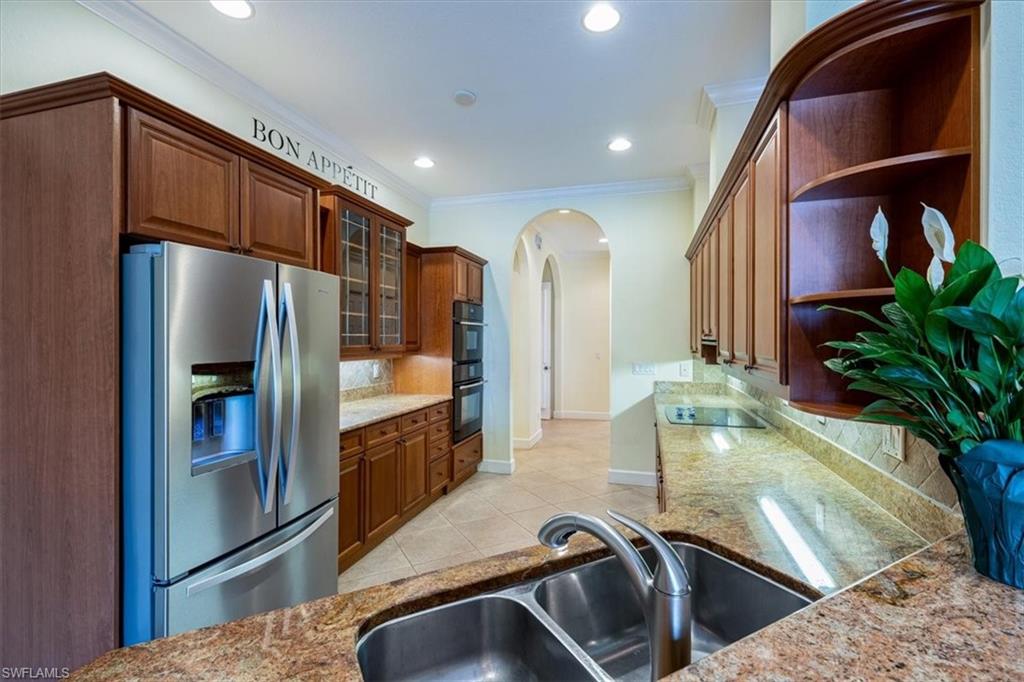 352 Steerforth Court Naples, FL 34110 - Photo 8 of 35 a kitchen with stainless steel appliances granite countertop a refrigerator a stove and a sink
