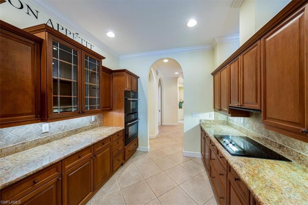 352 Steerforth Court Naples, FL 34110 - Photo 9 of 35 a large kitchen with kitchen island granite countertop a sink a counter top space and cabinets