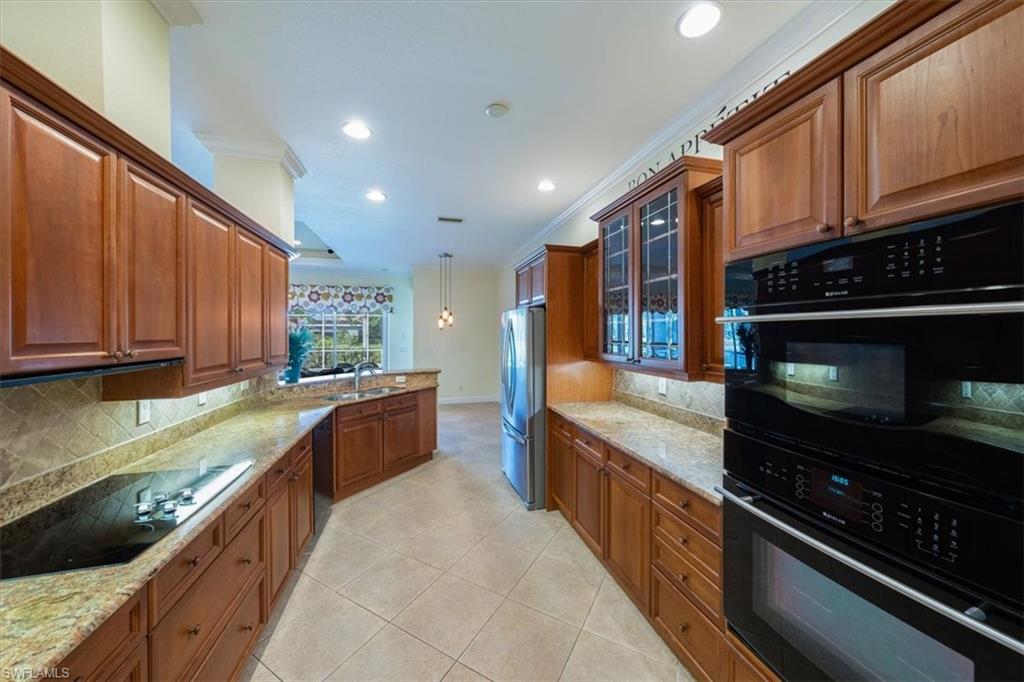 352 Steerforth Court Naples, FL 34110 - Photo 10 of 35 a large kitchen with stainless steel appliances granite countertop a stove and a sink