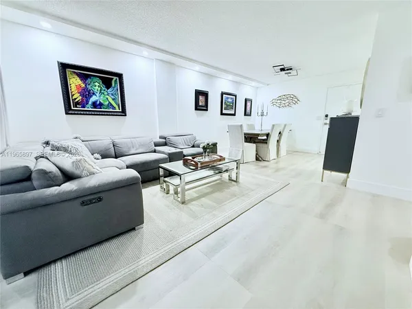 a living room with furniture and a view of kitchen