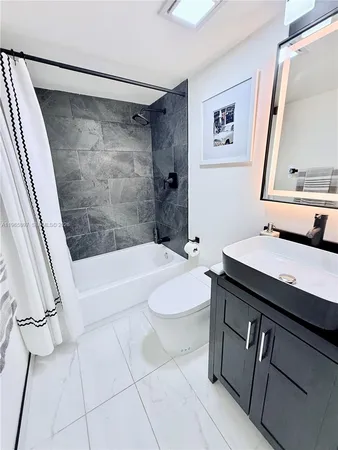 a bathroom with a sink a toilet a mirror and shower