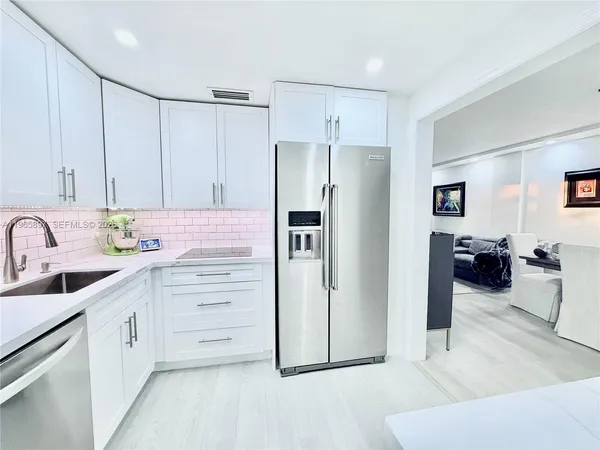 a kitchen with stainless steel appliances cabinets and a couch