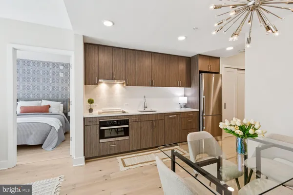 a kitchen with stainless steel appliances kitchen island granite countertop a refrigerator and a sink