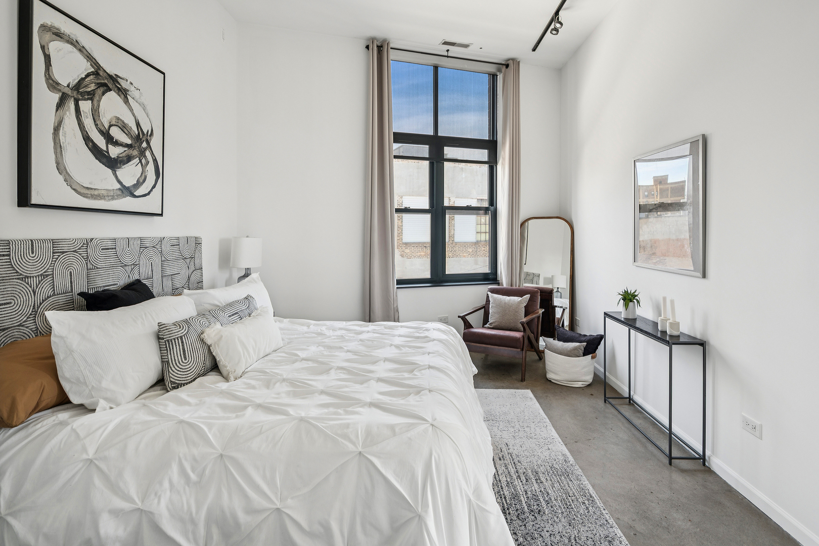 3631 North Halsted Street, Unit 308 Chicago, IL 60613 - Photo 12 of 20 a bedroom with bed and a large mirror