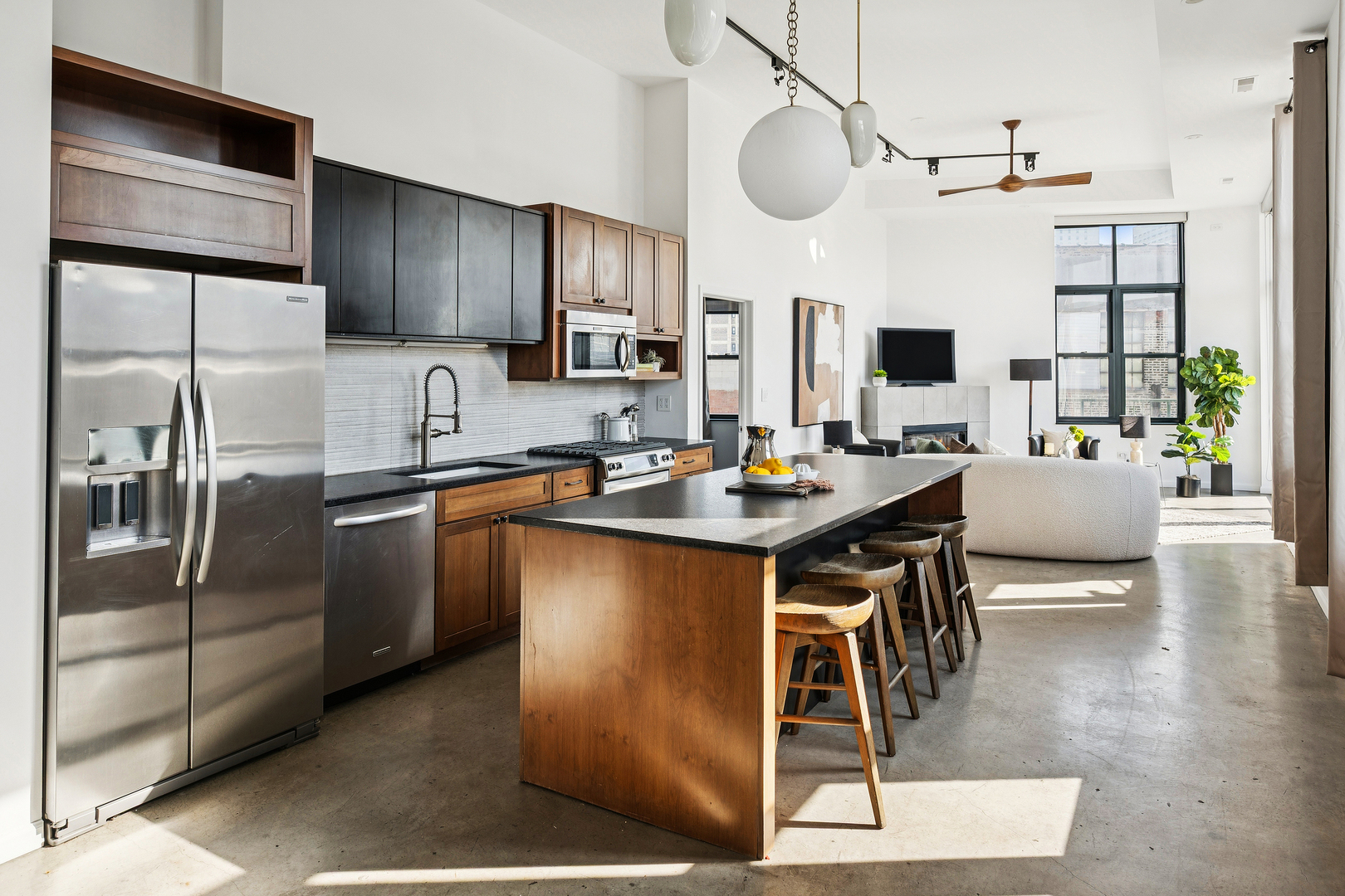 3631 North Halsted Street, Unit 308 Chicago, IL 60613 - Photo 2 of 20 a kitchen with stainless steel appliances kitchen island granite countertop a table chairs in it and wooden floors