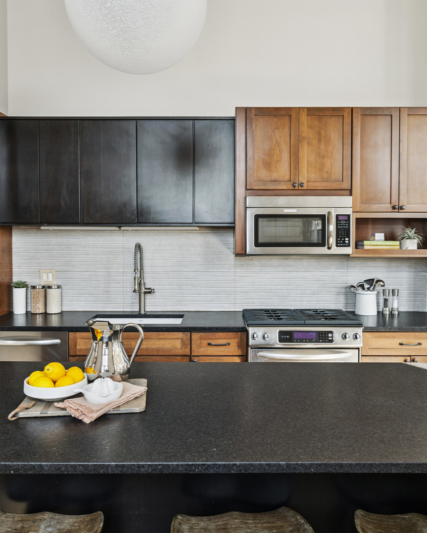 3631 North Halsted Street, Unit 308 Chicago, IL 60613 - Photo 7 of 20 a kitchen with stainless steel appliances granite countertop a stove a sink and a microwave