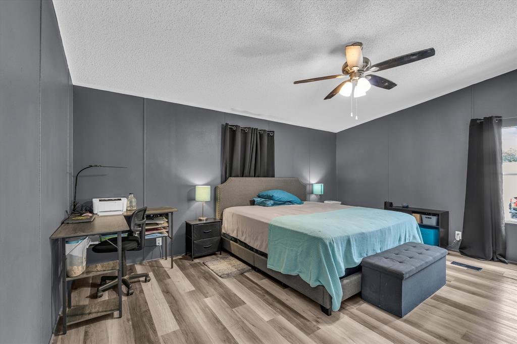 3615 Spring Valley Road Lorena, TX 76655 - Photo 26 of 33 Room featuring wood-finish flooring, a ceiling fan with integrated lighting, and paneled walls