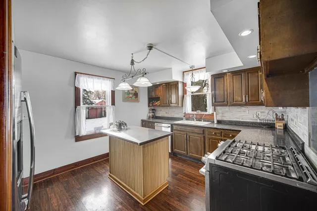 a kitchen with stainless steel appliances granite countertop a sink stove and refrigerator