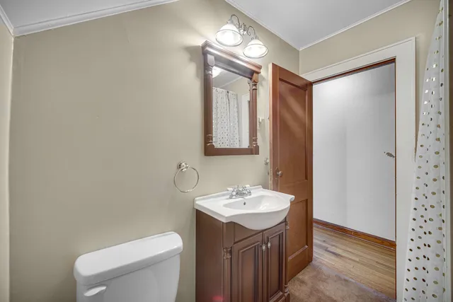 a bathroom with a toilet a sink and mirror