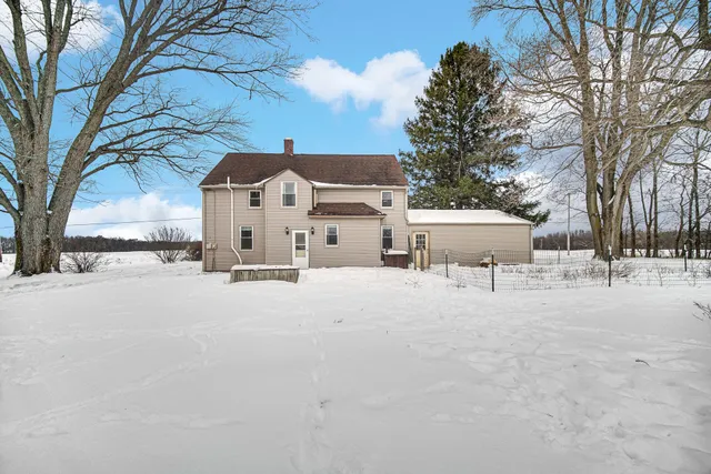 a view of a house with a yard covered in snow