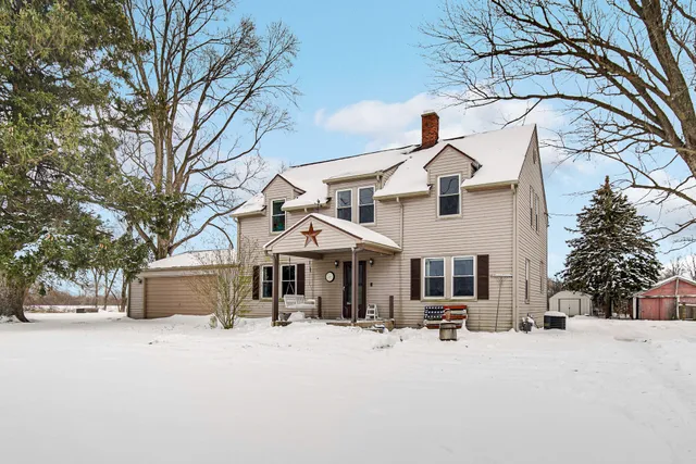 a view of a white house with a large tree in front of it