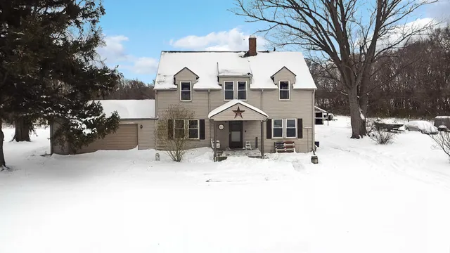 a view of a house with a yard covered in snow