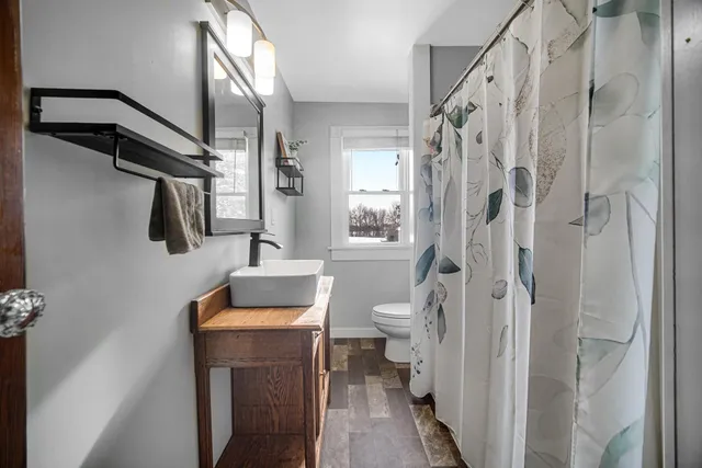 a bathroom with a toilet a sink and shower