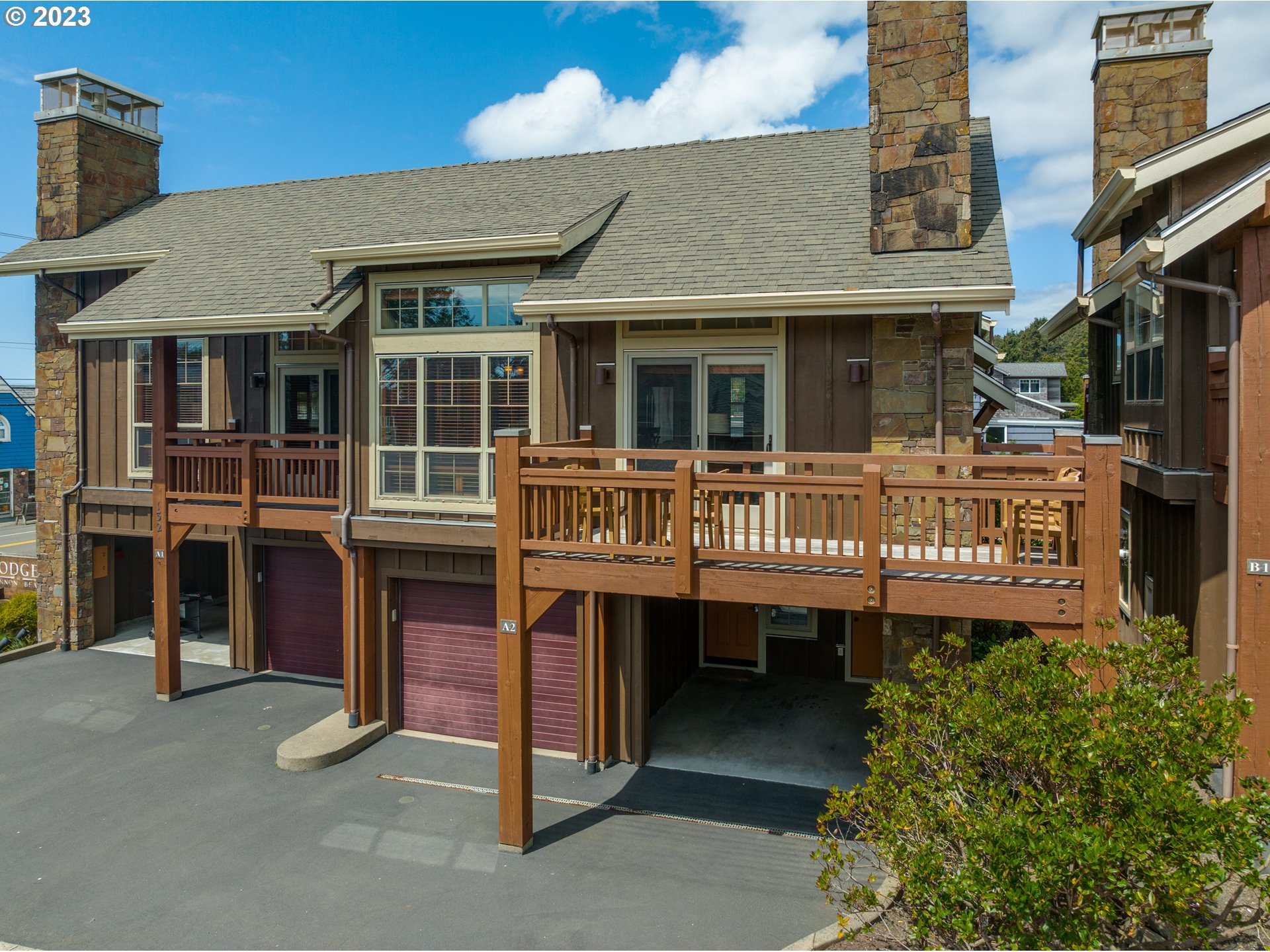 The Lodges, Unit A2C Cannon Beach, OR 97110 - Photo 1 of 46 a front view of a house with a garden and balcony