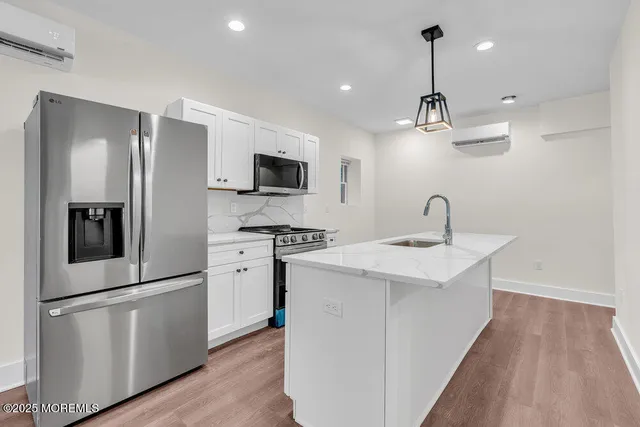 a kitchen with a sink stainless steel appliances a refrigerator and cabinets