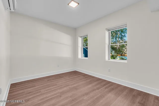 an empty room with wooden floor and window