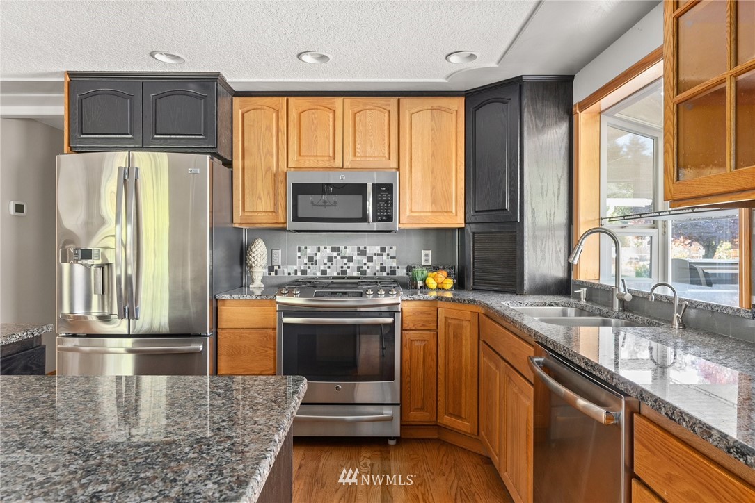 18741 Nutmeg Street Southwest Rochester, WA 98579 - Photo 16 of 39 a kitchen with stainless steel appliances granite countertop a stove a sink and a microwave