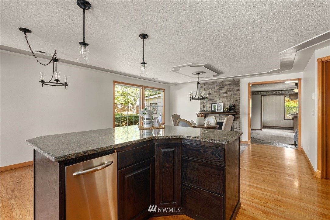 18741 Nutmeg Street Southwest Rochester, WA 98579 - Photo 17 of 39 a kitchen with granite countertop a sink cabinets and wooden floor