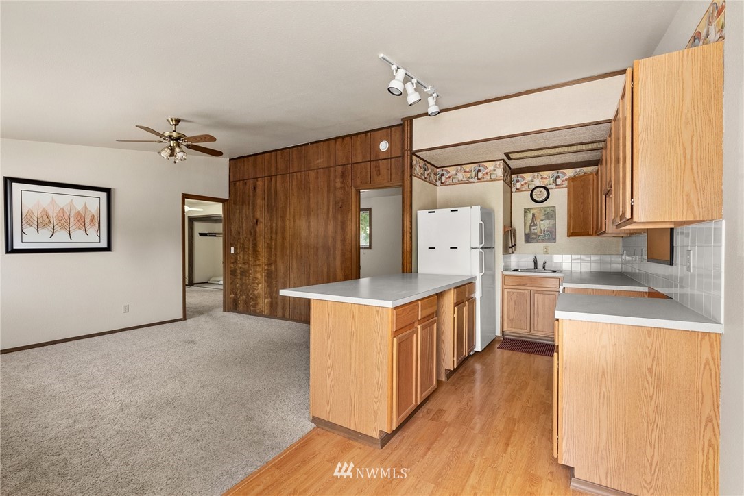 18741 Nutmeg Street Southwest Rochester, WA 98579 - Photo 33 of 39 a large kitchen with stainless steel appliances a stove a sink dishwasher and a refrigerator with wooden floor