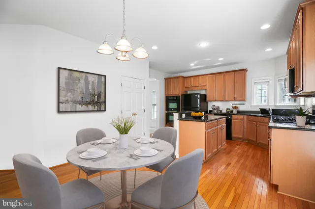 a view of a dining room with furniture a kitchen and chandelier