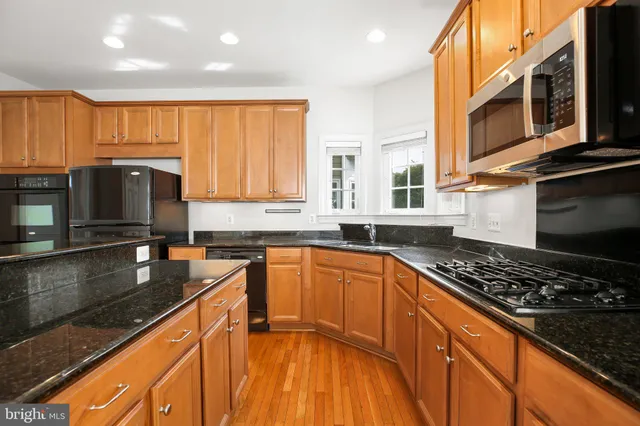a kitchen with stainless steel appliances a sink stove and cabinets