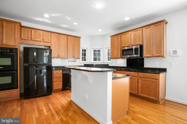 a kitchen with stainless steel appliances granite countertop a refrigerator stove top oven and sink