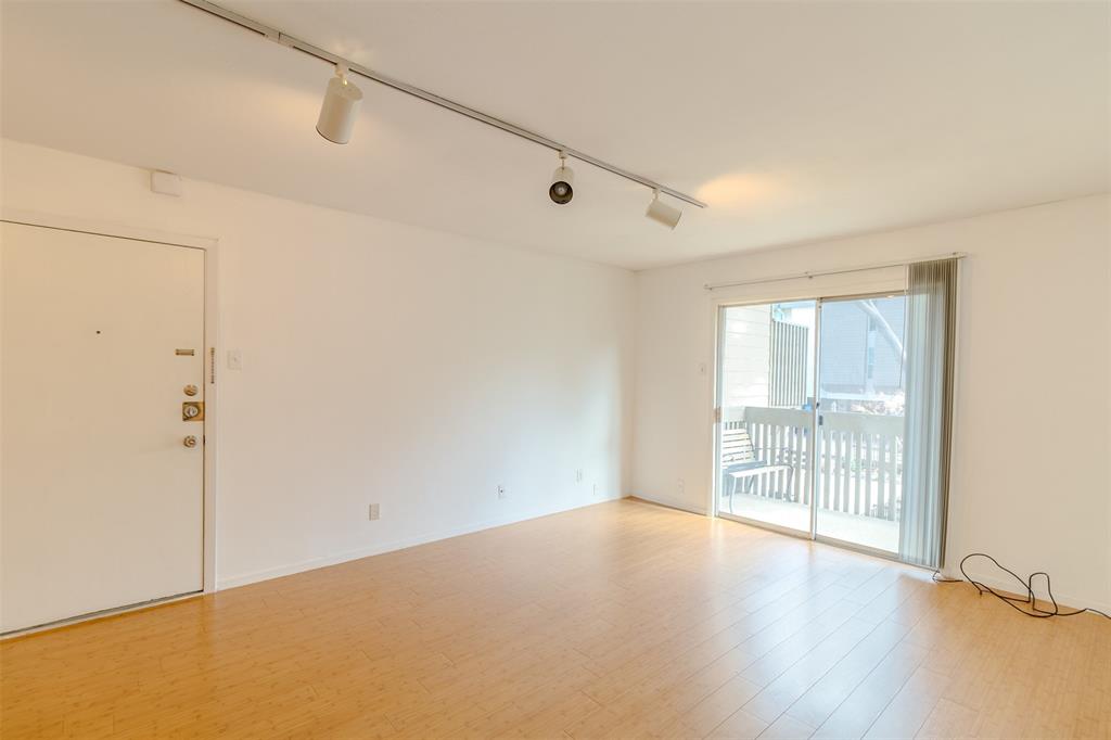 4859 Cedar Springs Road, Unit 234 Dallas, TX 75219 - Photo 15 of 30 a view of an empty room with wooden floor and a window