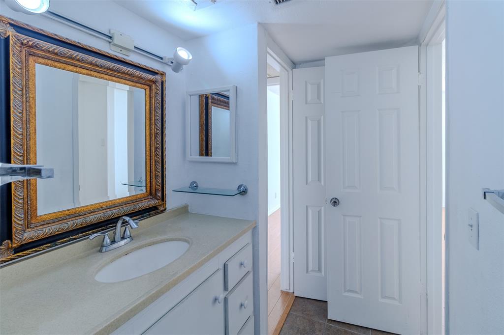 4859 Cedar Springs Road, Unit 234 Dallas, TX 75219 - Photo 16 of 30 a bathroom with a granite countertop sink and a mirror