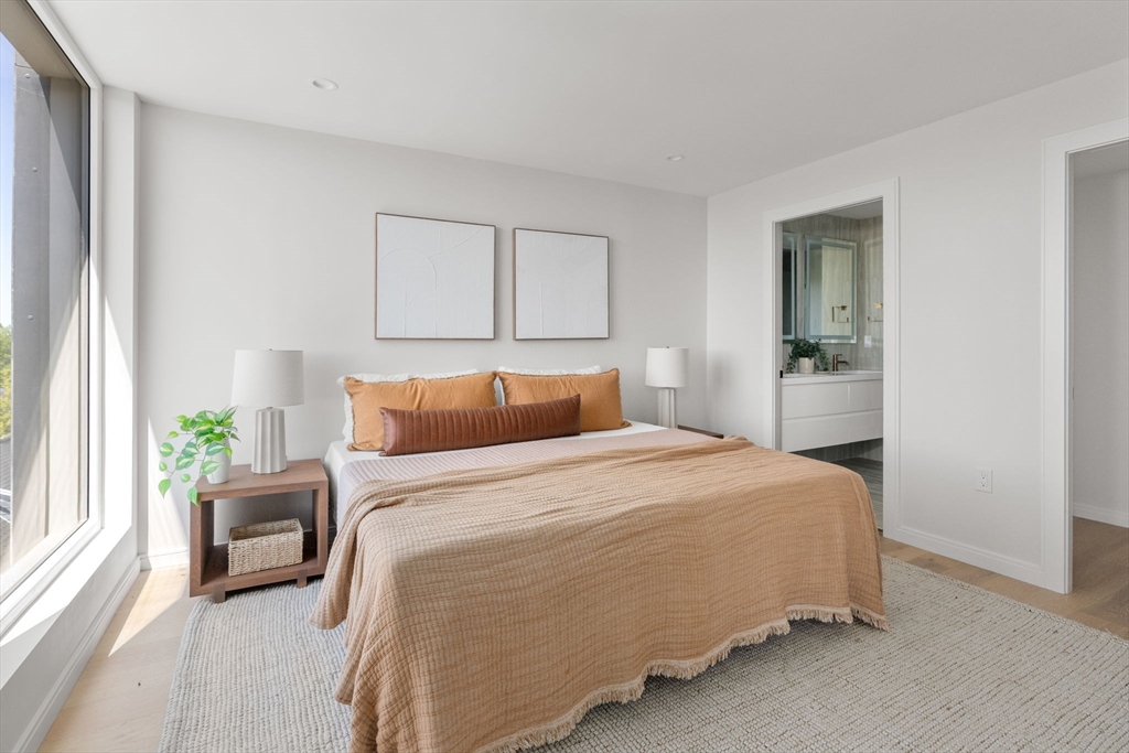 a bedroom with a bed lamp and a large window