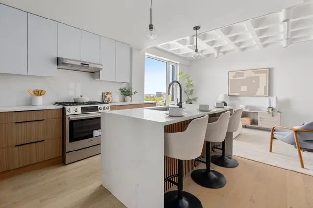 a kitchen with a sink stove and white cabinets with wooden floor