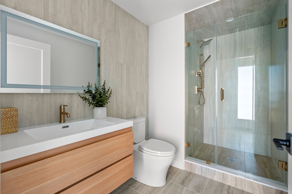 125 Lowell Street, Unit 503 Somerville, MA 02143 - Photo 4 of 17 a bathroom with a sink a toilet and shower