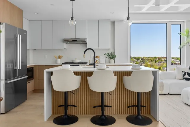 a kitchen with stainless steel appliances a sink a table and chairs