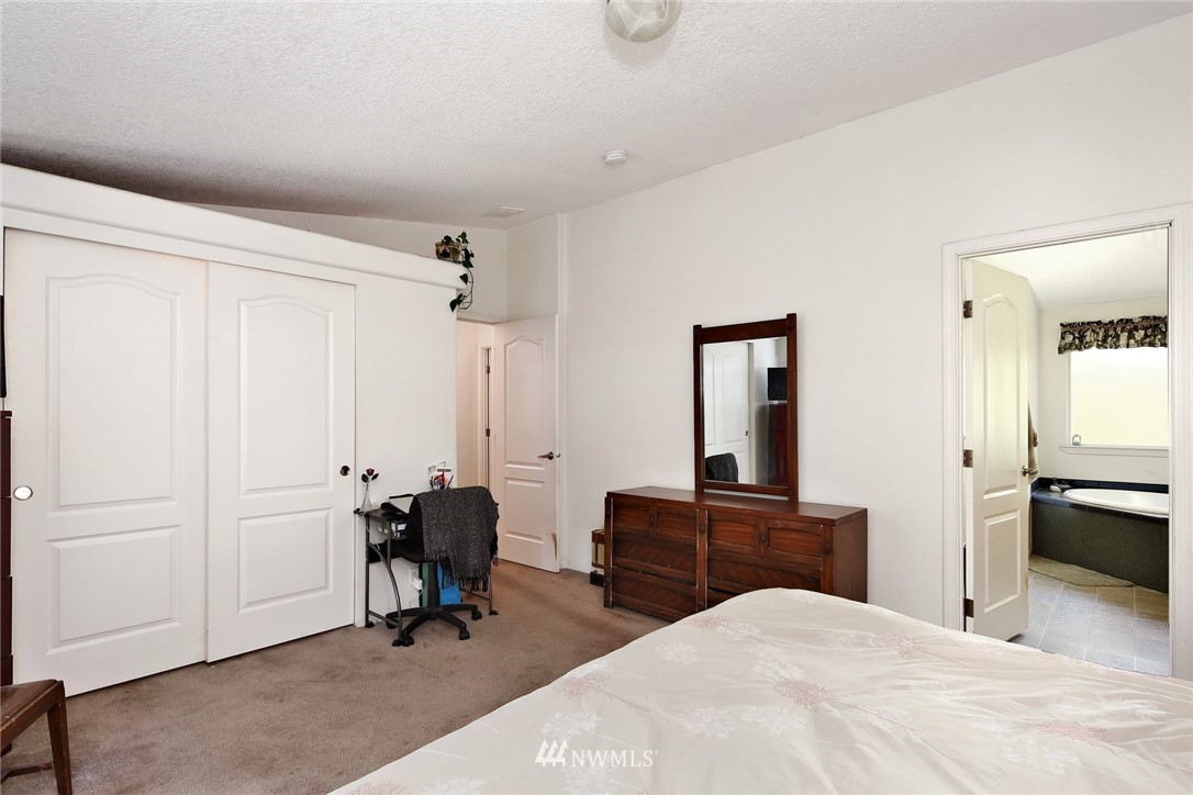 3125 Brown Road Ferndale, WA 98248 - Photo 12 of 24 a bedroom with a bed and a chandelier