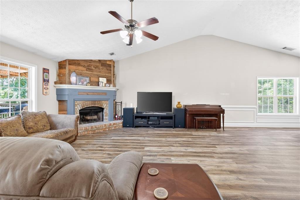89 Katie Spring Lane Jefferson, GA 30549 - Photo 20 of 63 a living room with furniture a fireplace and a flat screen tv