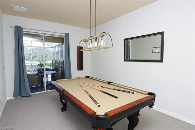 a room with pool table and windows