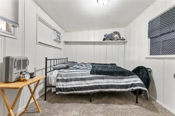 a bedroom with a bed chair and painting on the wall