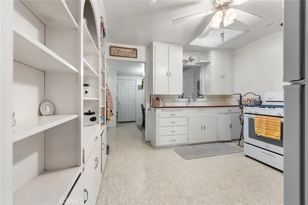 a view of a kitchen with stainless steel appliances kitchen island a sink cabinets and wooden floor