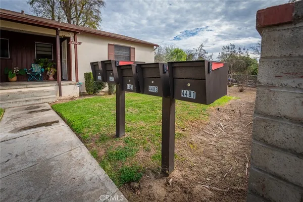 a view of a house with a yard and potted plants