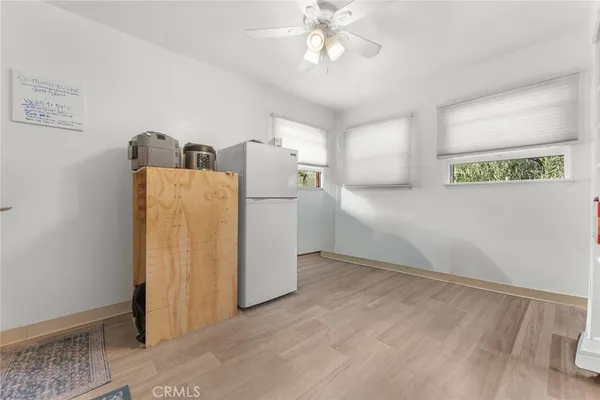 a view of a kitchen with a refrigerator cabinets and a ceiling fan