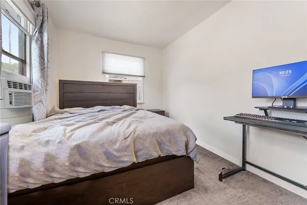 a bedroom with a bed and a potted plant
