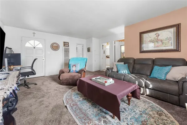 a living room with furniture a rug and wall paintings